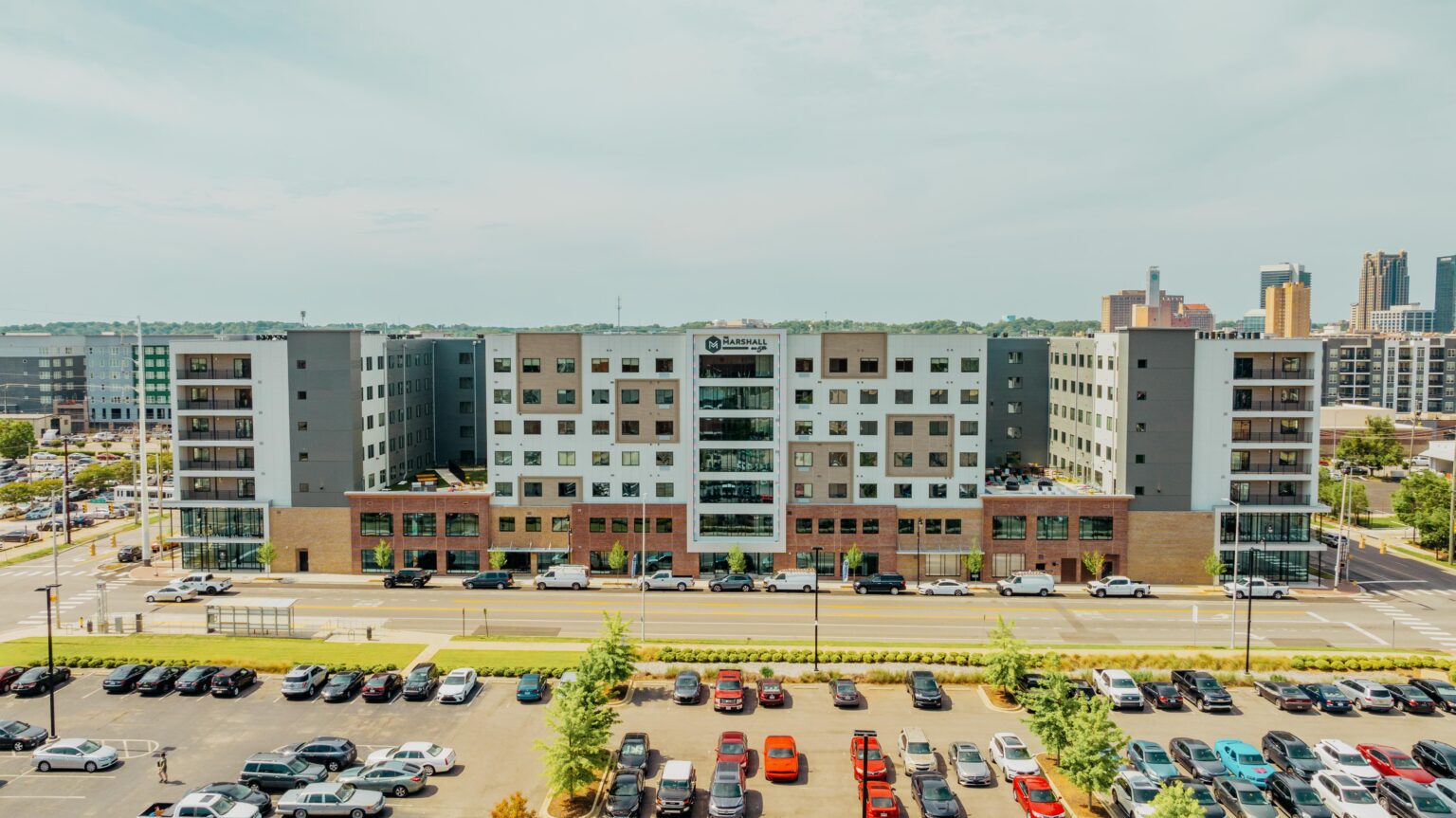 Exterior photo of The Marshall on 5th, with parking lot and skyline.